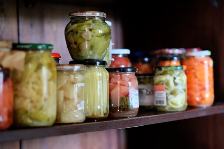 Mason jars filled with home-preserved vegetables on a shelf